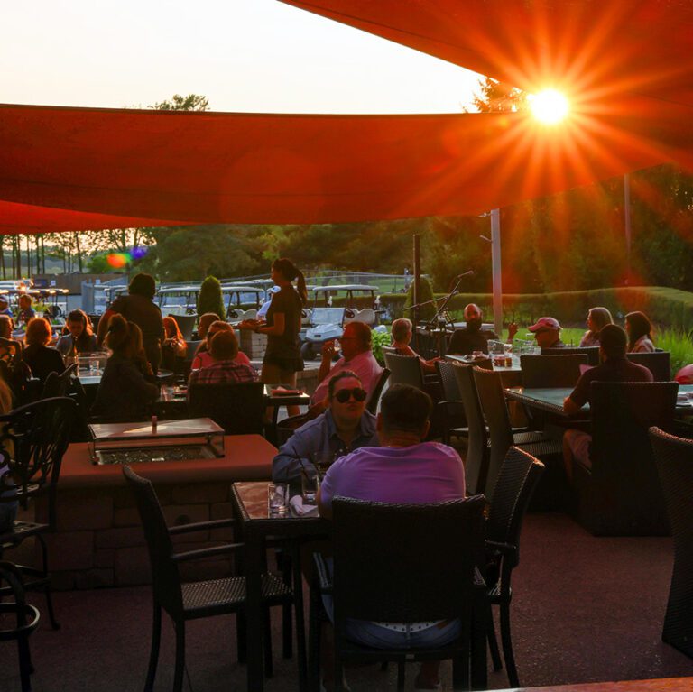 sunset at parkside grille patio with guests enjoying outdoor dining
